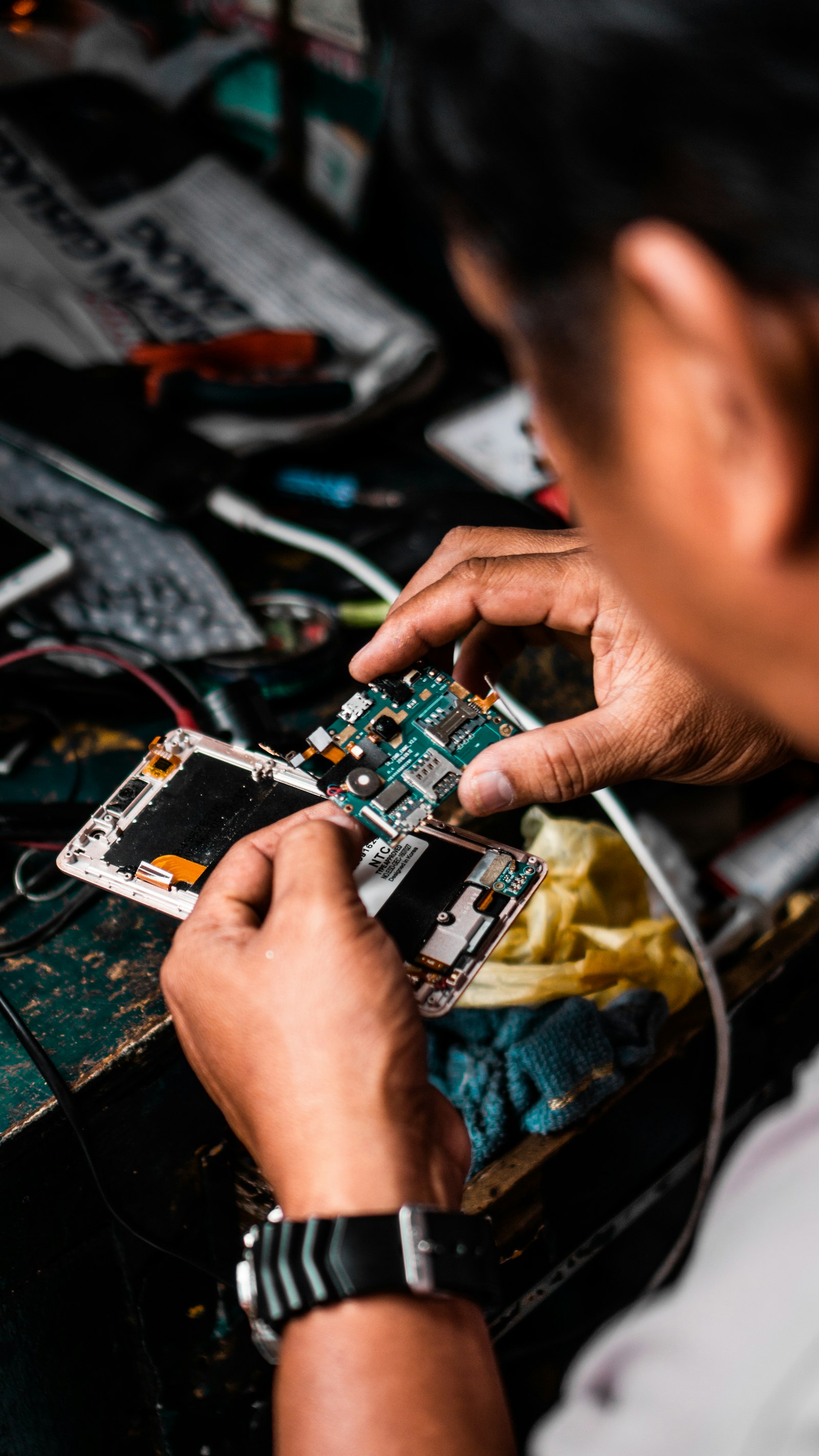 Tehnician reparând un telefon (imagine ilustrativă)